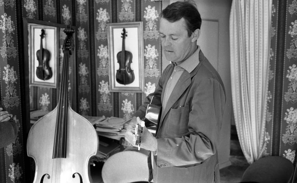 Svend Asmussen spelar gitarren i en butik.Violiner Italienska mästarvioliner i Örebro. Musiktest.Interiör.